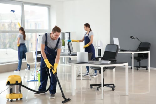 Una squadra di pulizie professionali che lavora in un ufficio moderno, con attrezzature e prodotti di qualità per garantire un ambiente di lavoro pulito e ordinato.