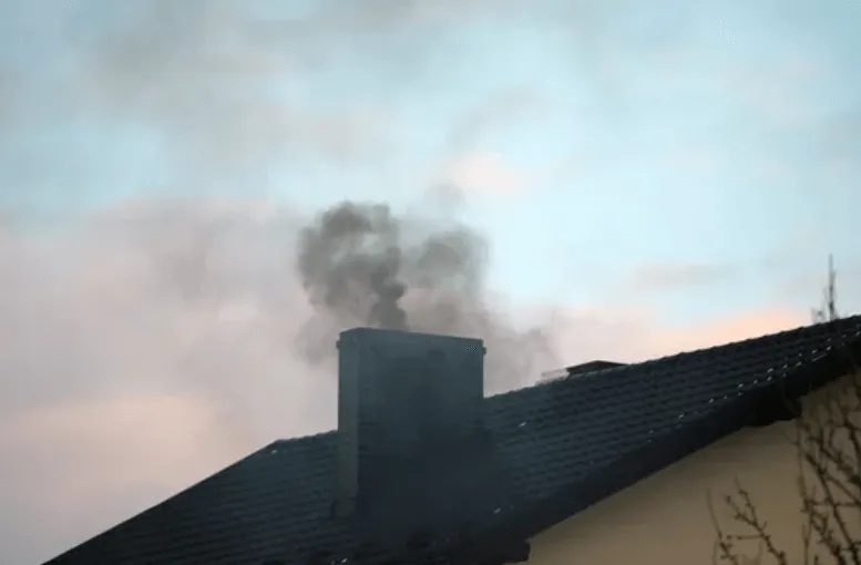 Fumo nero che esce dal camino di un'abitazione